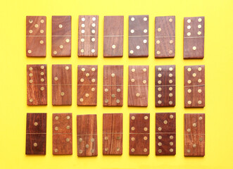 Many wooden dominos blocks on yellow background