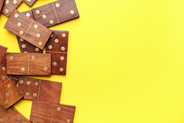 Many wooden dominos blocks on yellow background