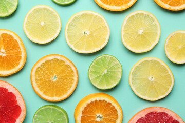 Different citrus slices on turquoise background