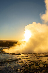 Stokkur geyser spectacular eruption in front of the sun , Iceland
