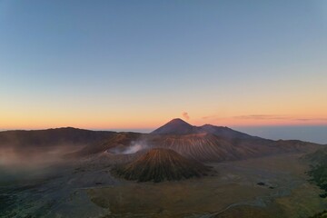 Majestic sunrise over Bromo volcano in Indonesia with smoke rising in the distance