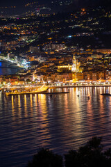 Night view on French Riviera, lights of Menton old city and marina on blue Mediterranean Sea near French-Italian border, Monaco, Monte-Carlo, travel destination, panoramic view