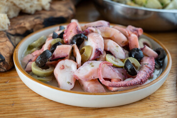 Tasty salad or starter seafood dish, grilled octopus ligurian style with green and black olives served in Italian  restaurant