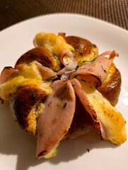 Rolls with cheese and ham baked in the oven and served on a plate.
