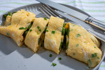 Chicken eggs omelette stuffed with green asparagus, tasty vegetarian food, french cuisine, close up