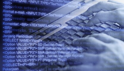 Hands typing on laptop computer with programming code