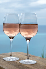 Summer time in Provence, two glasses of cold rose wine with blue sea view on background, French Riviera near Menton, south of France
