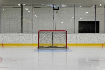 Empty ice hockey rink with goal net.