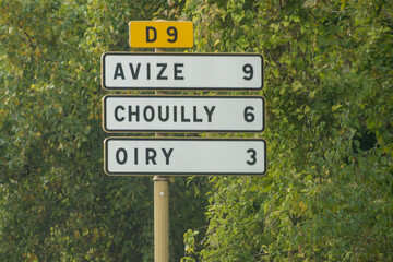 Obraz premium Road signes and places of destinations, Gran Cru villages, black road sign english translation: tourists route. Autumn in Champagne wine making region near Epernay, France. 