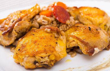 Closeup of tasty chicken thighs with pearl barley at plate on table