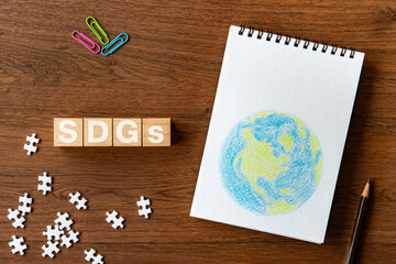 There is wood cube with the word SDGs. It is an abbreviation for Sustainable Development Goals as...