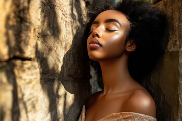 Fototapeta premium A serene portrait of a woman with natural makeup, eyes closed, against a stone background.