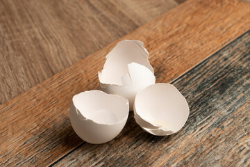 cáscaras de huevo blanco sobre una superficie con textura de madera