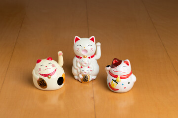 tres figuras de gatos blancos maneki neko con la pata arriba para la buena suerte