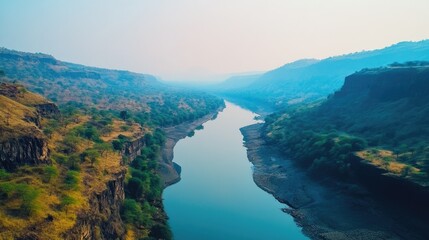 An aerial view of a calm river flowing through a valley surrounded by hills