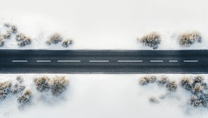 Aerial view of a snow-covered road with sparse vegetation on either side.