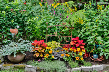 Obraz premium USA, Washington State, Sammamish. Summer perennial flower garden with zinnias. Beebalms. Coleus, lawn art. (PR)