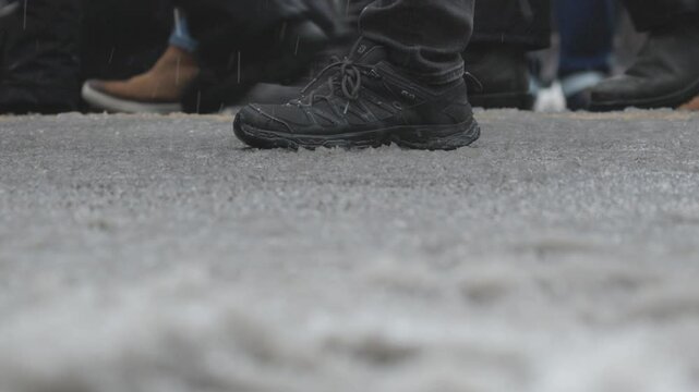 A crowd of boots on the ground walking and marching in the snow