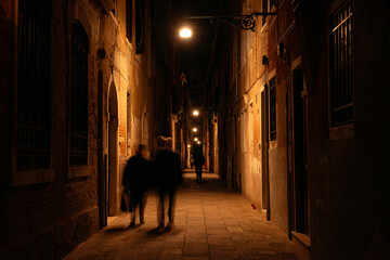 Silhouettes in the lantern light in a narrow alleyway