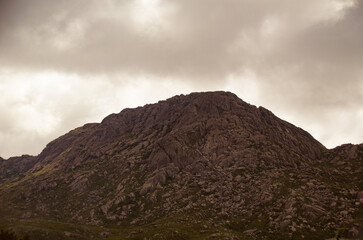 Agulhas Negras peak in Itatiaia National Park, with rugged rock formations under an overcast sky.