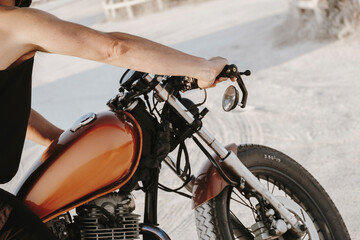 Biker riding vintage motorcycle on a sandy beach