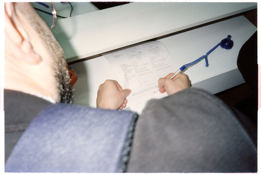 Anonymous young male model signing documents in counter 