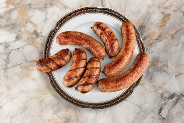 Grilled tasty pork sausages on plate