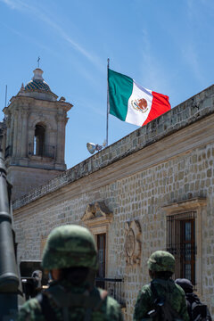 Mexican Flag in blue sky at army parade 