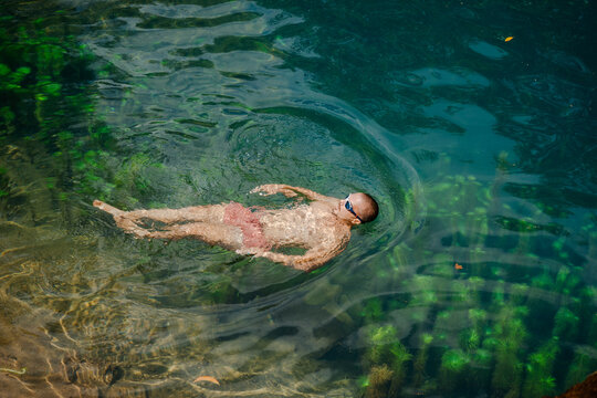 Man Floating Calmly on a Clear Lake Surface