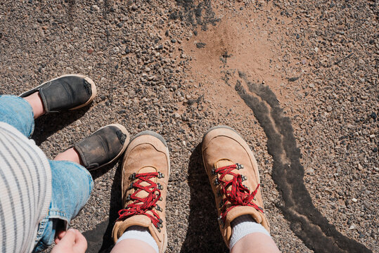 Mother and son with beat-up shoes and hiking boots