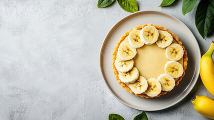 Elegant banana tart on simple plate, surrounded by fresh leaves and bananas, creating delightful presentation