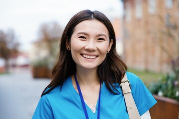 Portrait of partial young happy asian female nurse looking at camera