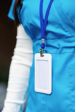 Partial view of female nurse wearing uniform and empty badge outdoors