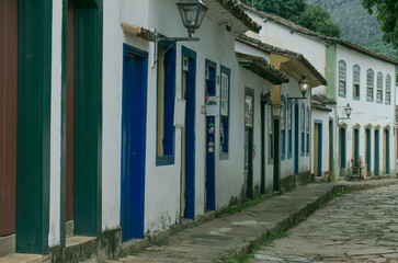 Obraz premium Colonial street with colorful doors and windows along a cobblestone path in Tiradentes, Brazil.