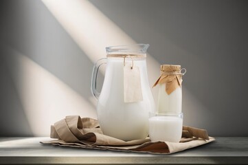 Glass and jug with tasty fresh healthy milk