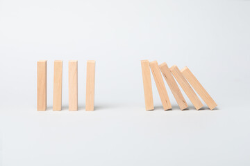 Domino effect. Wooden blocks falling on light background