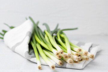 Fresh green onions on white table, closeup