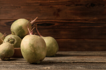 Whole fresh turnips on wooden table, space for text