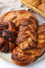 Different sweet pastries on white tiled table, closeup