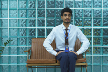 Man Sitting on Leather Bench with Hands on Hips