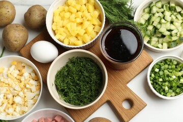 Different ingredients for okroshka soup on white table, flat lay