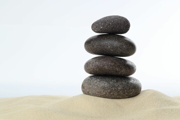 Stack of rocks on sand against white background, space for text. Harmony and life balance