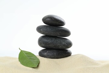Stack of rocks on sand against white background. Harmony and life balance