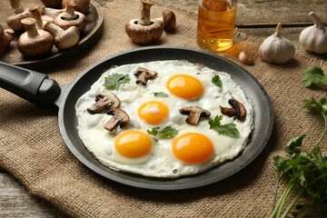 Tasty fried eggs with mushrooms and parsley served on wooden table