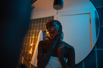 Young woman admiring herself in mirror