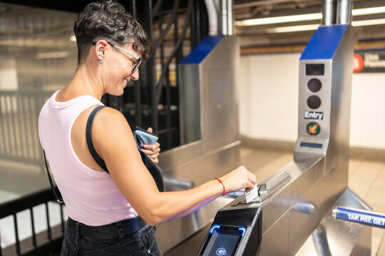Tourist using omny card at turnstile entering new york city