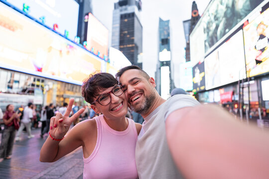 Happy couple taking selfie in Times Square, New York City