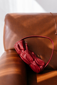 Maroon leather bag placed on sofa