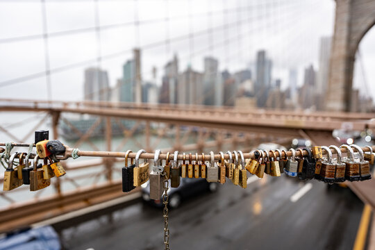 Padlocks hanging on a wire of the Brooklyn Bridge symbolize love