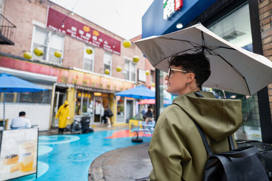 Tourist walking in Chinatown, New York City, on a rainy day